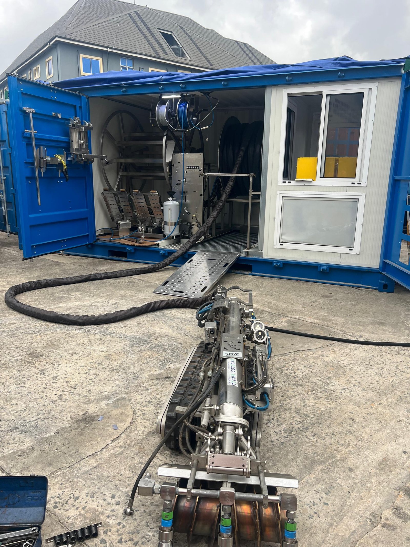 No man entry tank cleaning equipment with a tracked cleaning unit and container workshop